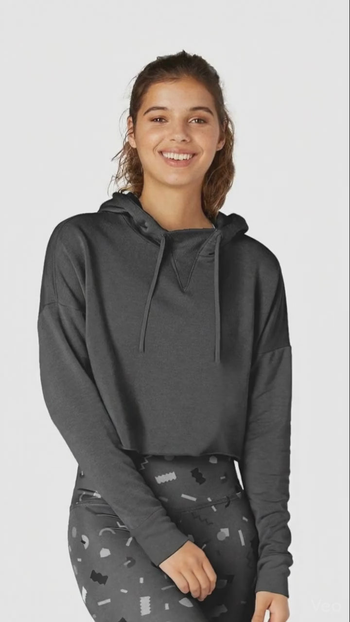 Woman wearing a dark gray hoodie with a plain background