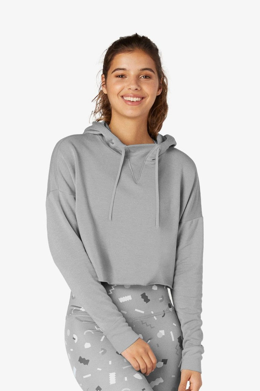 Woman wearing a gray hoodie with a white background