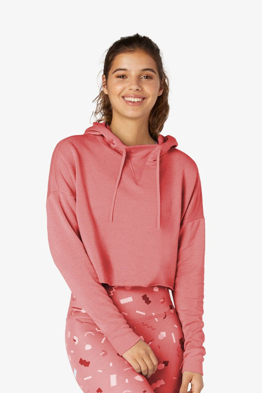 Person wearing a pink hoodie and pants with heart patterns on a white background