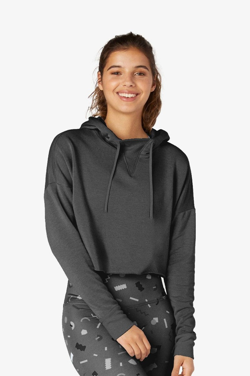 Woman wearing a dark gray hoodie with a plain background