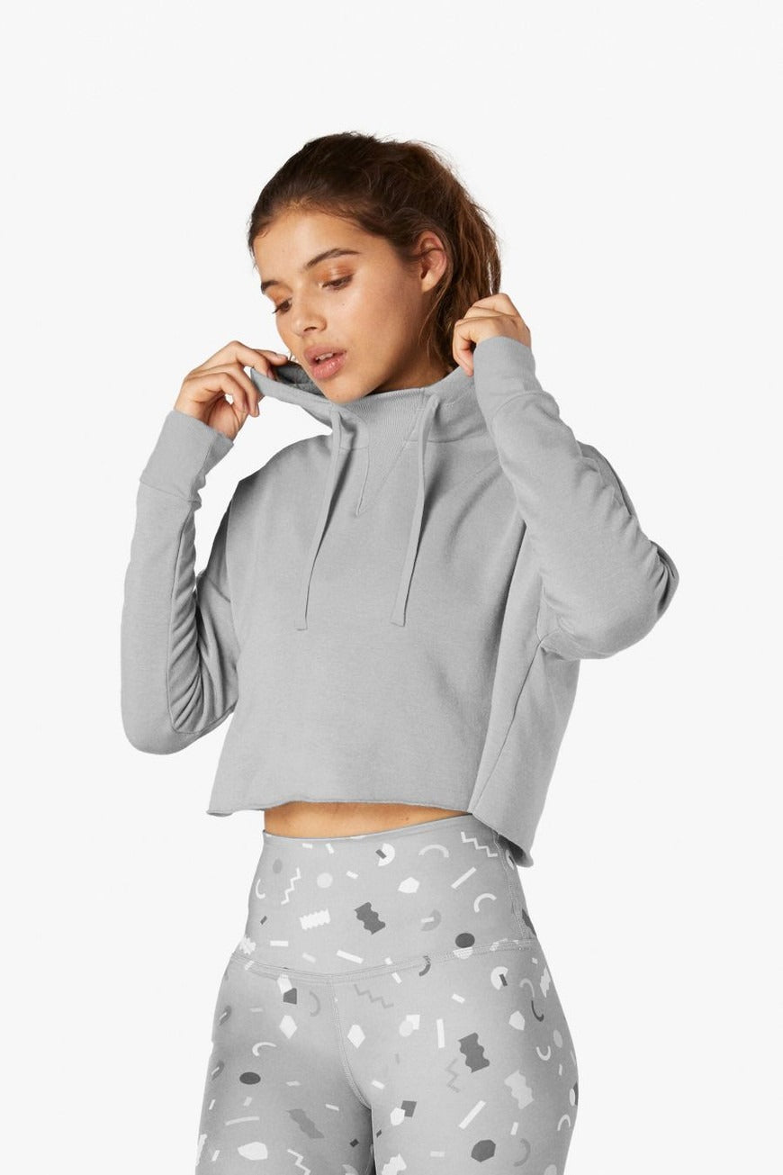 Woman wearing a gray hoodie with a white background