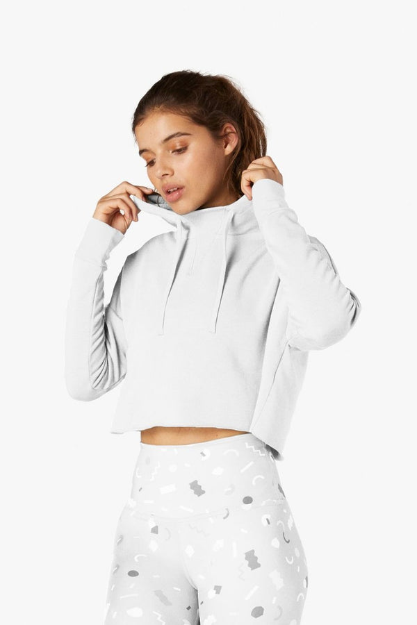 Woman wearing a light gray hoodie with a white background