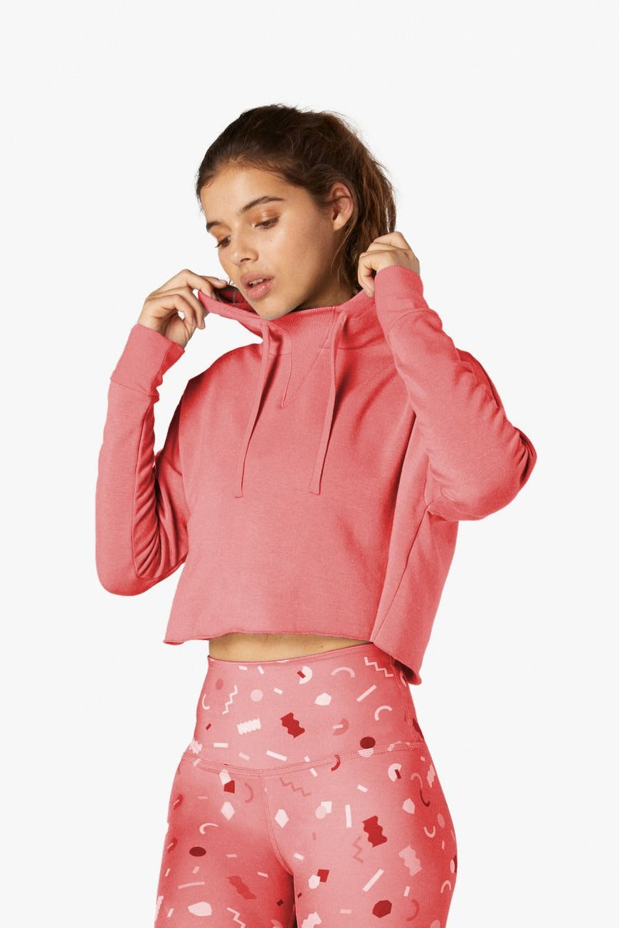 Person wearing a pink hoodie and pants with heart patterns on a white background