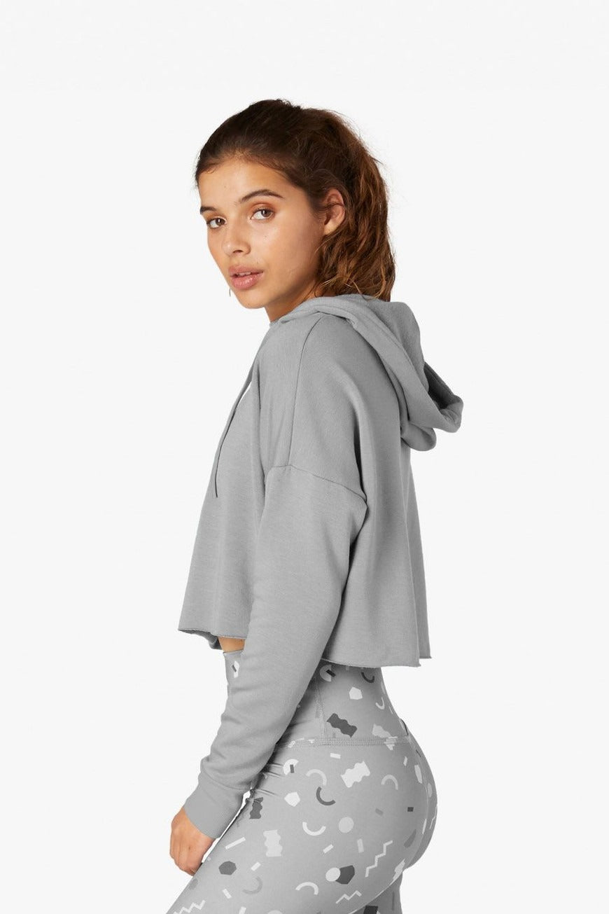 Woman wearing a gray hoodie with a white background